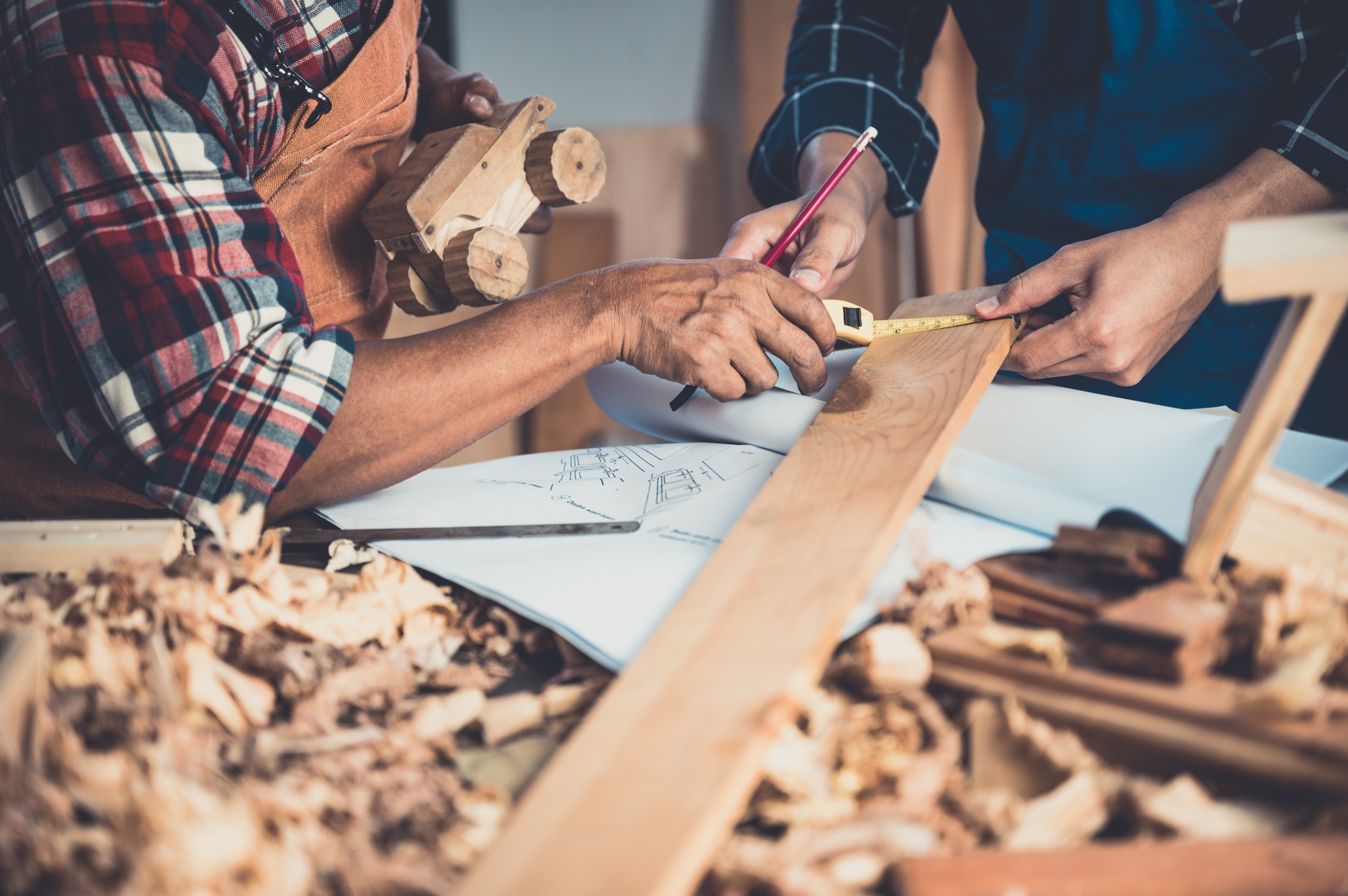 Carpenter working on woodworking machines in carpentry shop