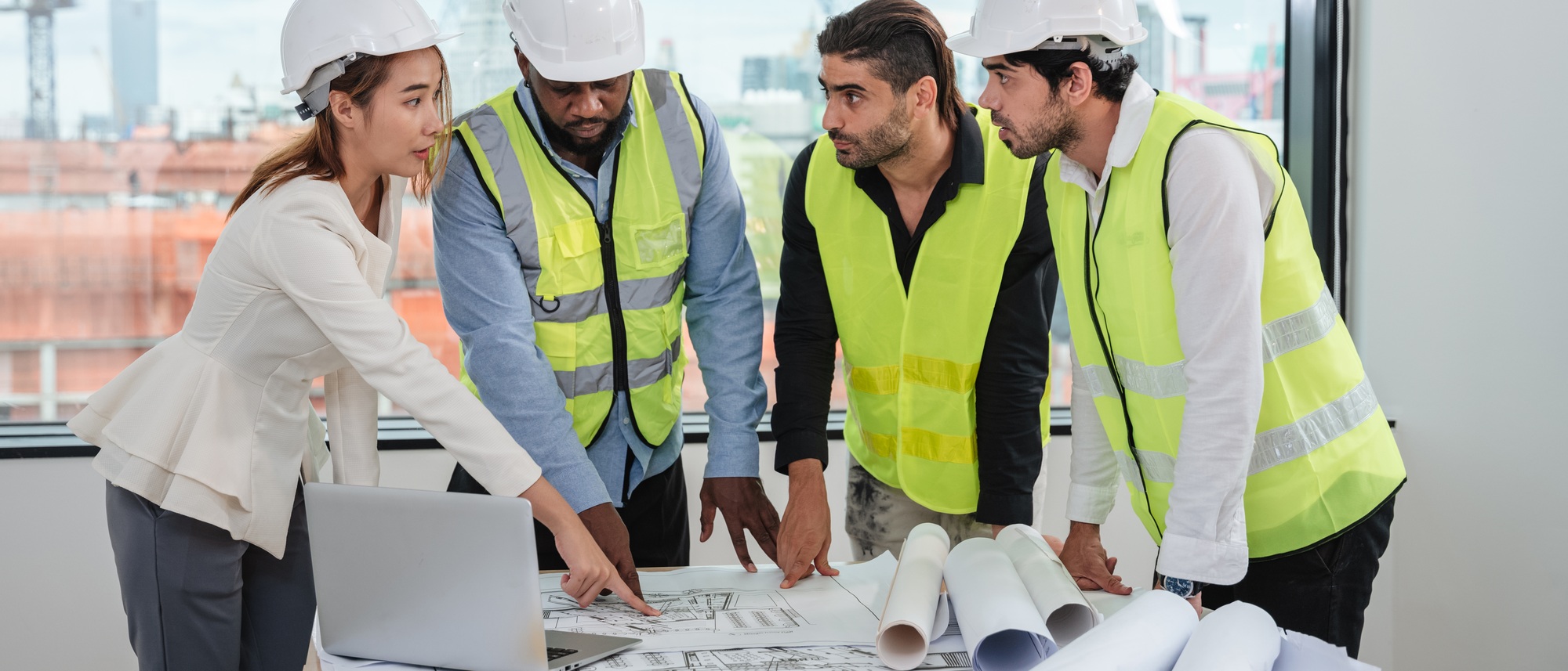 Engineers meet in the office to work on an architectural project as a team.